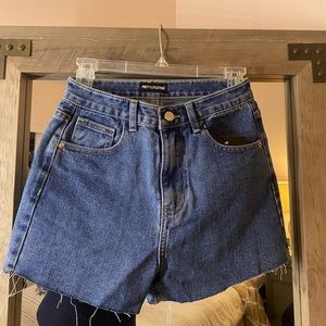 PrettyLittleThing Mid blue wash denim with pockets and a raw hem design.